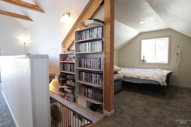 bedroom featuring lofted ceiling, dark colored carpet, and a textured ceiling