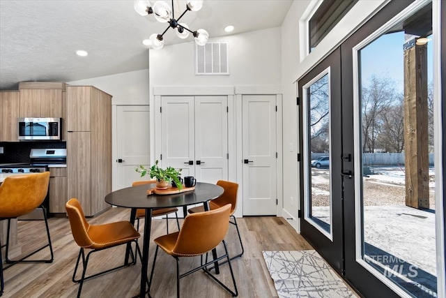 362-436 W London St, Middleton, ID 83644 - dining area featuring visible vents, a textured ceiling, french doors, light wood-style floors, and a notable chandelier