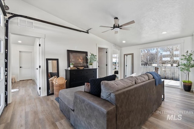 362-436 W London St, Middleton, ID 83644 - living area featuring visible vents, a ceiling fan, light wood-style flooring, vaulted ceiling, and a textured ceiling