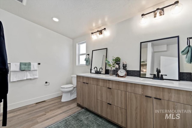 362-436 W London St, Middleton, ID 83644 - full bathroom featuring double vanity, tasteful backsplash, toilet, a sink, and wood finished floors