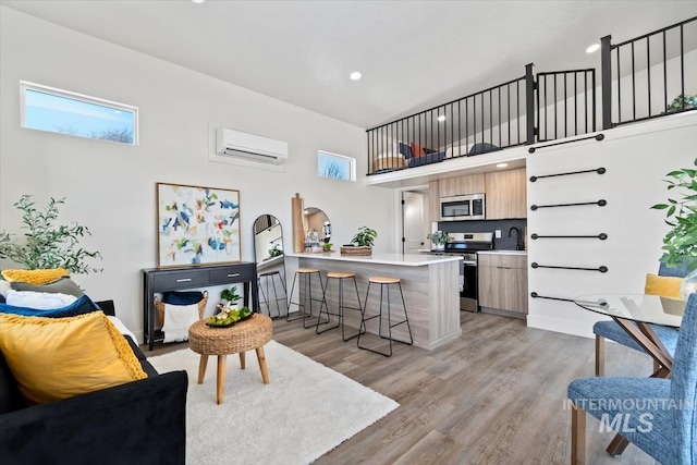 362-436 W London St, Middleton, ID 83644 - kitchen featuring a breakfast bar area, light countertops, a wall mounted AC, appliances with stainless steel finishes, and modern cabinets