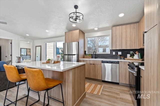 362-436 W London St, Middleton, ID 83644 - kitchen with a sink, light countertops, appliances with stainless steel finishes, a center island, and modern cabinets