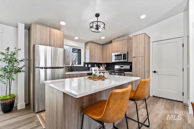 362-436 W London St, Middleton, ID 83644 - kitchen featuring a center island, decorative light fixtures, light countertops, appliances with stainless steel finishes, and modern cabinets