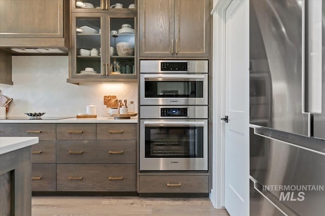 12013 W Zamalek Ct, Kuna, ID 83634 - kitchen with stainless steel appliances, decorative backsplash, light wood-style floors, and light countertops