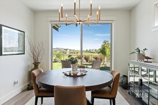 12013 W Zamalek Ct, Kuna, ID 83634 - dining area with a chandelier, plenty of natural light, and wood finished floors