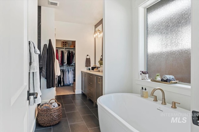 12013 W Zamalek Ct, Kuna, ID 83634 - bathroom with a freestanding bath, tile patterned flooring, vanity, a walk in closet, and plenty of natural light