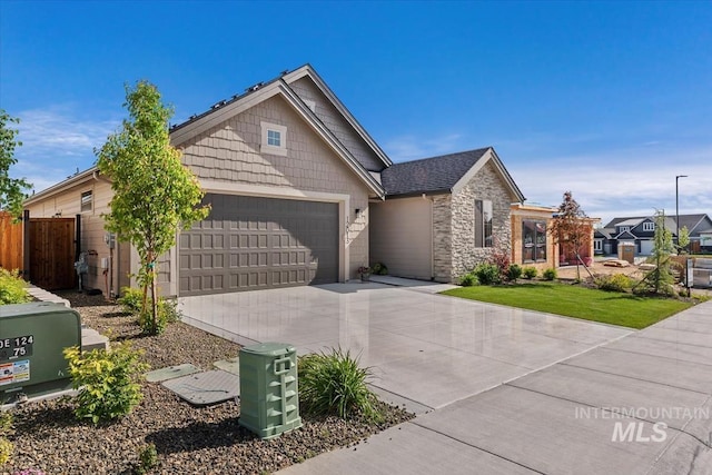 12013 W Zamalek Ct, Kuna, ID 83634 - view of front facade featuring an attached garage, concrete driveway, and stone siding