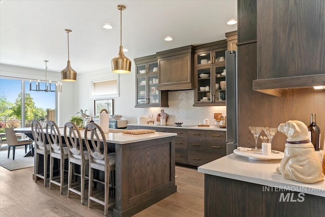 12013 W Zamalek Ct, Kuna, ID 83634 - kitchen with a kitchen island, dark brown cabinetry, light wood finished floors, light countertops, and recessed lighting