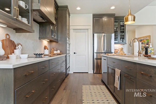 12013 W Zamalek Ct, Kuna, ID 83634 - kitchen with appliances with stainless steel finishes, premium range hood, dark wood-style flooring, dark brown cabinetry, and recessed lighting