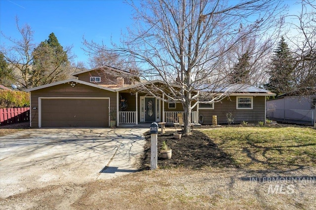 ranch-style house with covered porch, driveway, an attached garage, and fence