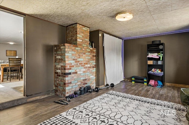 playroom featuring baseboards and wood finished floors