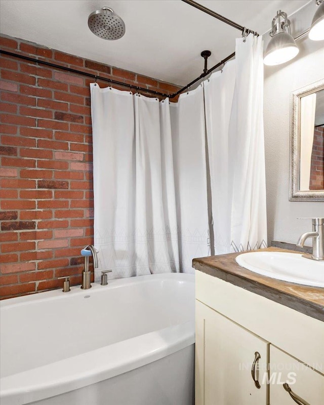 full bathroom featuring a shower with shower curtain, a bathing tub, brick wall, and vanity