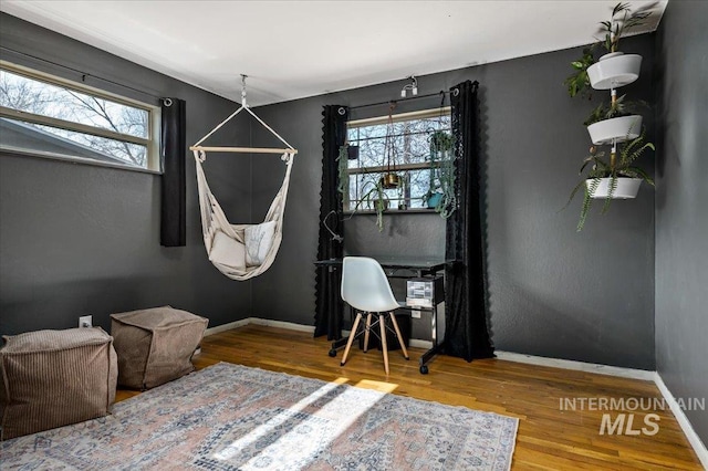 interior space with baseboards and wood finished floors