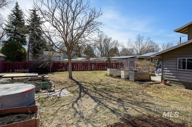 view of yard featuring a patio area, a fenced backyard, and a garden