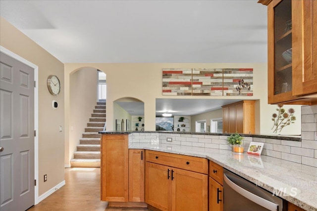 1049 N Purple Sage Way, Eagle, ID 83616 - kitchen featuring dishwasher, light stone countertops, a peninsula, backsplash, and light wood finished floors