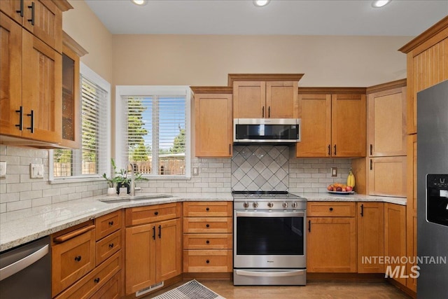 1049 N Purple Sage Way, Eagle, ID 83616 - kitchen with appliances with stainless steel finishes, light stone counters, decorative backsplash, recessed lighting, and wood finished floors