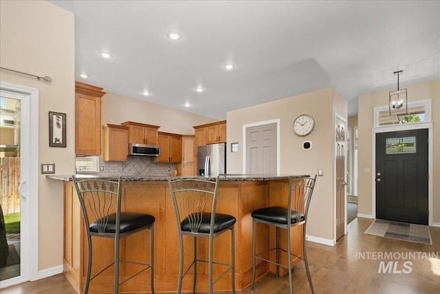 1049 N Purple Sage Way, Eagle, ID 83616 - kitchen featuring stainless steel appliances, dark wood-type flooring, a peninsula, a breakfast bar, and recessed lighting