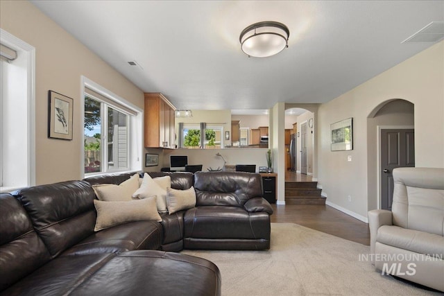 1049 N Purple Sage Way, Eagle, ID 83616 - carpeted living room with arched walkways, stairs, and wood finished floors