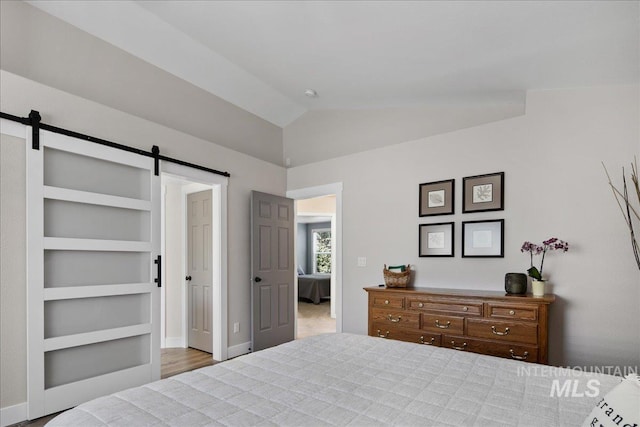 1049 N Purple Sage Way, Eagle, ID 83616 - bedroom featuring a barn door and vaulted ceiling
