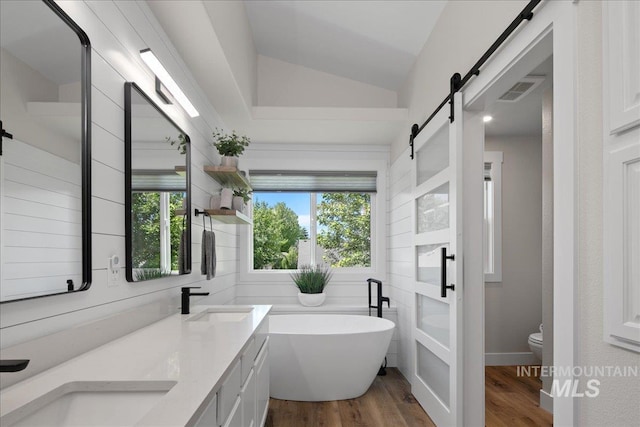 1049 N Purple Sage Way, Eagle, ID 83616 - bathroom featuring a soaking tub, wood finished floors, double vanity, and vaulted ceiling