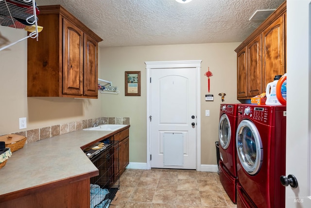 4965 S Nickel Creek Ave, Meridian, ID 83642 - clothes washing area featuring a sink, cabinet space, a textured ceiling, washing machine and clothes dryer, and baseboards