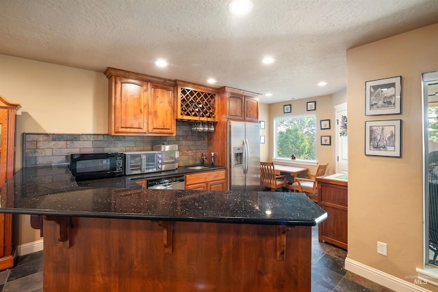 4965 S Nickel Creek Ave, Meridian, ID 83642 - kitchen with baseboards, a textured ceiling, stainless steel appliances, and a sink