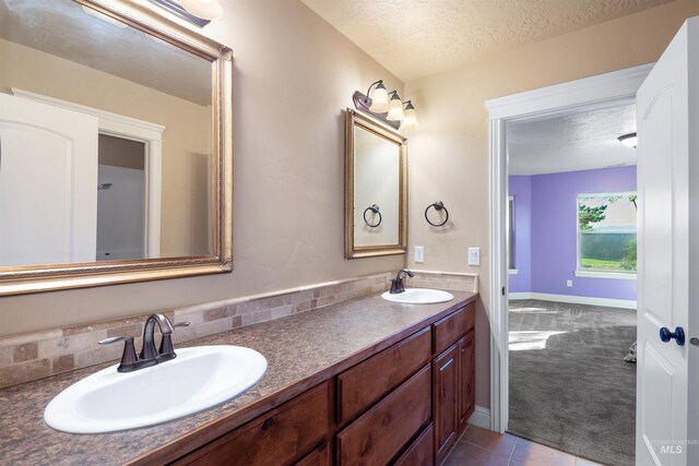 4965 S Nickel Creek Ave, Meridian, ID 83642 - bathroom with double vanity, tile patterned floors, a textured ceiling, and a sink