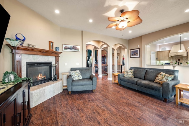 4965 S Nickel Creek Ave, Meridian, ID 83642 - living area featuring dark wood-type flooring, a fireplace, a ceiling fan, and arched walkways