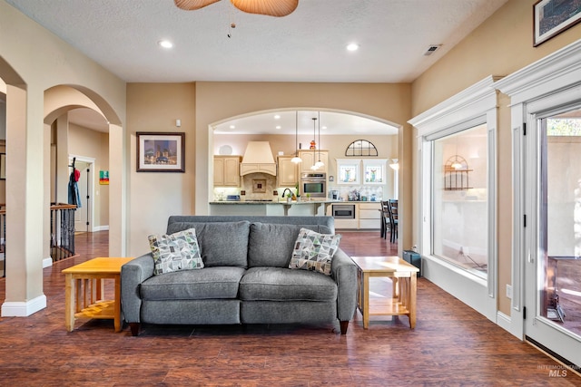 4965 S Nickel Creek Ave, Meridian, ID 83642 - living room with dark wood-type flooring, visible vents, ceiling fan, arched walkways, and recessed lighting