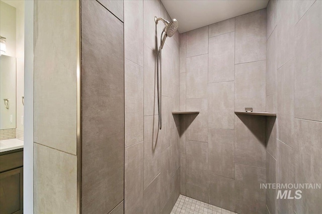 full bathroom featuring vanity and tiled shower