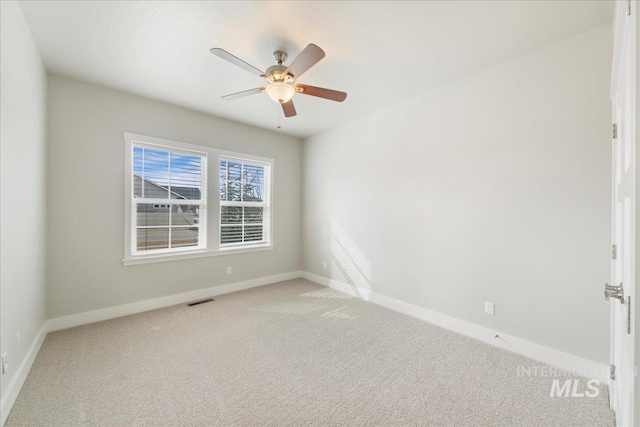 empty room featuring ceiling fan, baseboards, visible vents, and light carpet