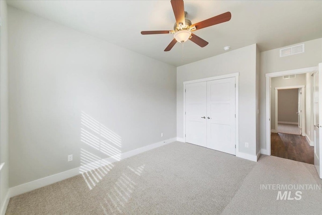 unfurnished bedroom with a closet, visible vents, baseboards, and carpet floors