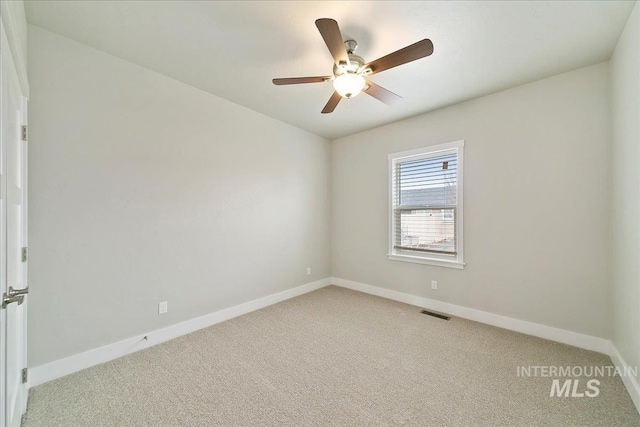 unfurnished room featuring a ceiling fan, visible vents, light colored carpet, and baseboards