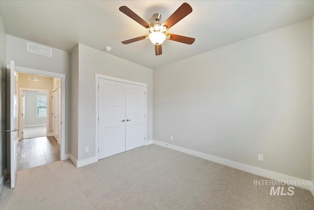 unfurnished bedroom with visible vents, carpet floors, baseboards, and a closet