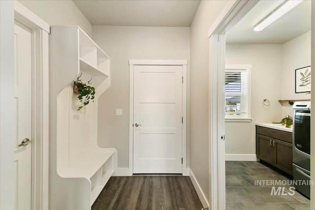 mudroom featuring dark wood finished floors and baseboards