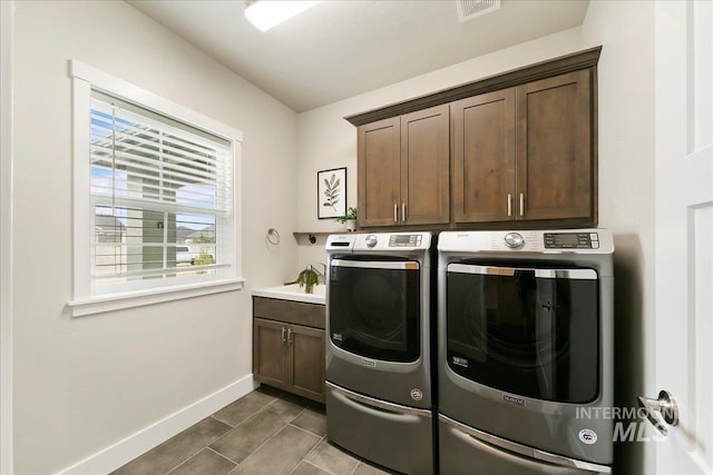 laundry area featuring visible vents, cabinet space, baseboards, and washing machine and clothes dryer