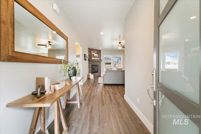 hall featuring a wealth of natural light, baseboards, wood finished floors, and recessed lighting