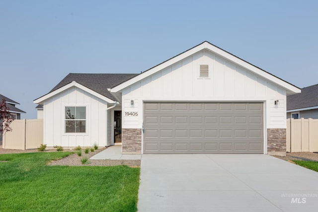 11069 Canvas St, Caldwell, ID 83605 - modern inspired farmhouse featuring stone siding, concrete driveway, fence, board and batten siding, and a garage