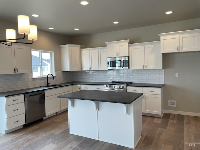 467 Hope Ave, Twin Falls, ID 83301 - kitchen with stainless steel appliances, a sink, dark countertops, white cabinetry, and recessed lighting