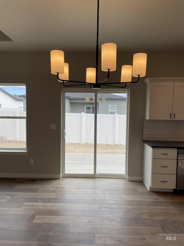 467 Hope Ave, Twin Falls, ID 83301 - unfurnished dining area featuring baseboards, wood finished floors, and a chandelier