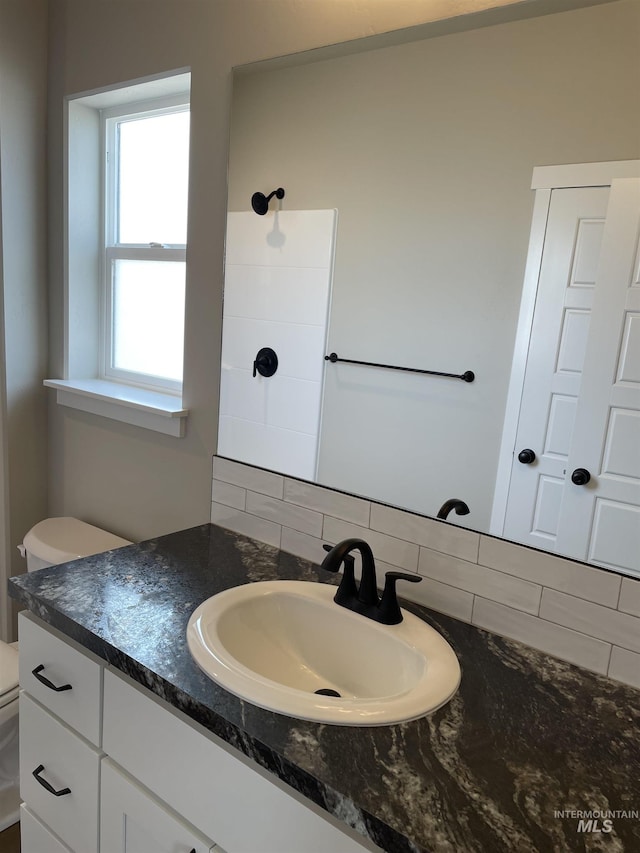 467 Hope Ave, Twin Falls, ID 83301 - bathroom with backsplash, toilet, vanity, and a shower