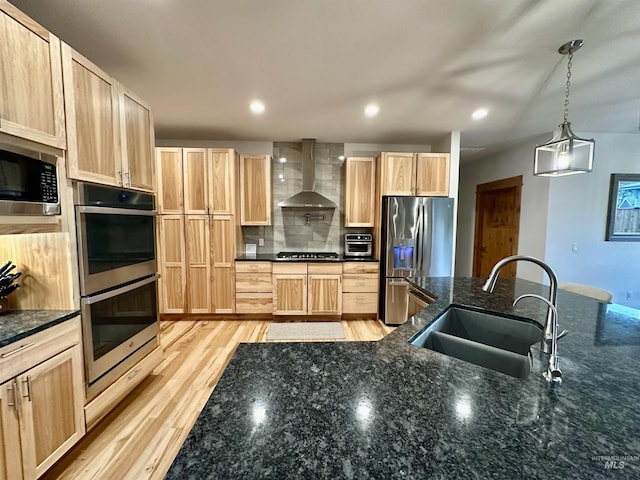 1321 Lande Ln, Moscow, ID 83843 - kitchen with light brown cabinets, a sink, wall chimney range hood, stainless steel appliances, and light wood finished floors