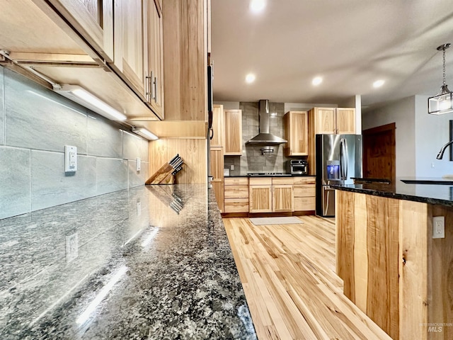 1321 Lande Ln, Moscow, ID 83843 - kitchen with light brown cabinetry, stainless steel refrigerator with ice dispenser, backsplash, stovetop, and wall chimney exhaust hood