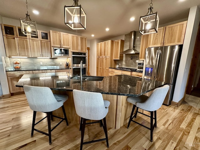1321 Lande Ln, Moscow, ID 83843 - kitchen with tasteful backsplash, wall chimney range hood, light brown cabinetry, appliances with stainless steel finishes, and light wood-style floors