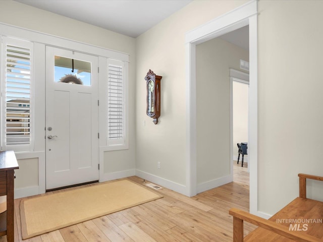 foyer with baseboards and light wood finished floors