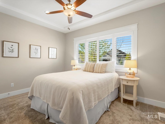 bedroom with a ceiling fan, baseboards, and light carpet