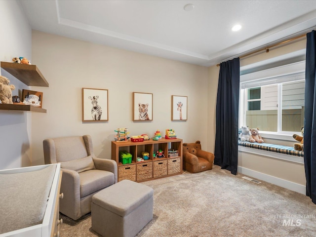 playroom featuring baseboards, visible vents, light carpet, and a raised ceiling