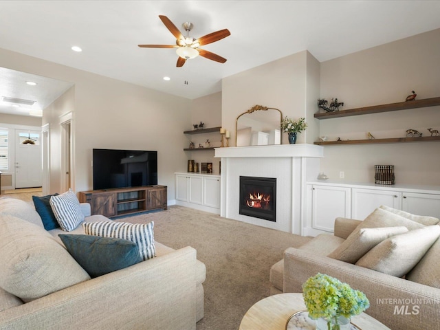 living area featuring light carpet, a glass covered fireplace, a ceiling fan, recessed lighting, and visible vents