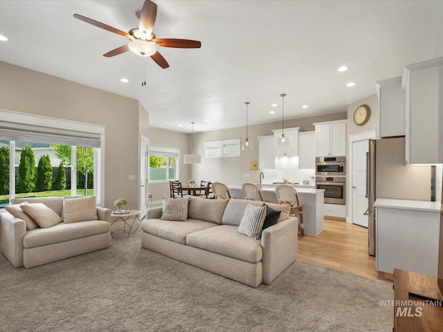 living room with recessed lighting, ceiling fan, and light wood-style floors