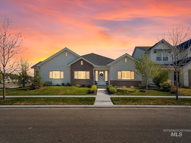 ranch-style house with brick siding, a front lawn, and board and batten siding